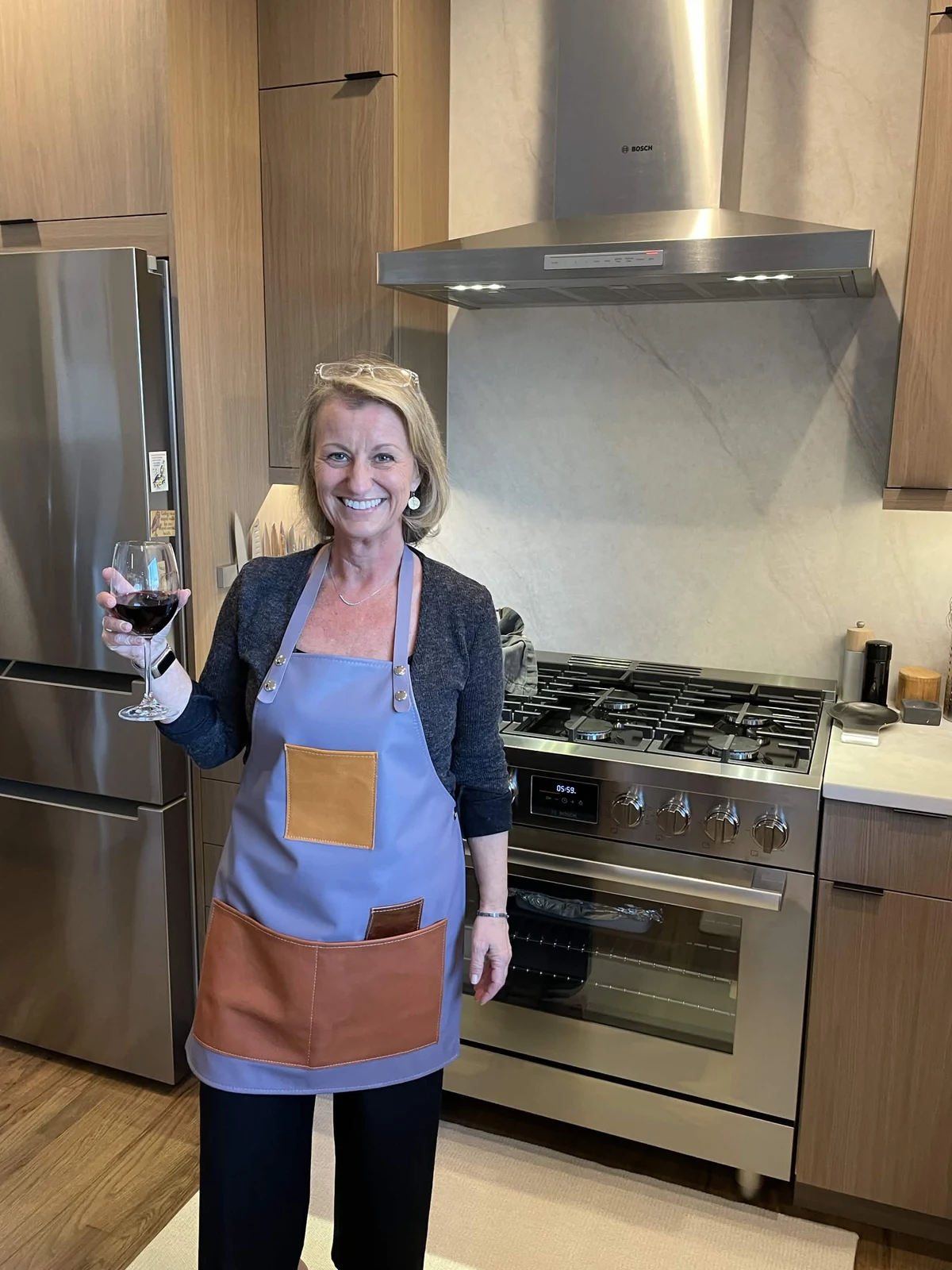 Customer wearing a blue leather apron with contrasting pockets in a kitchen