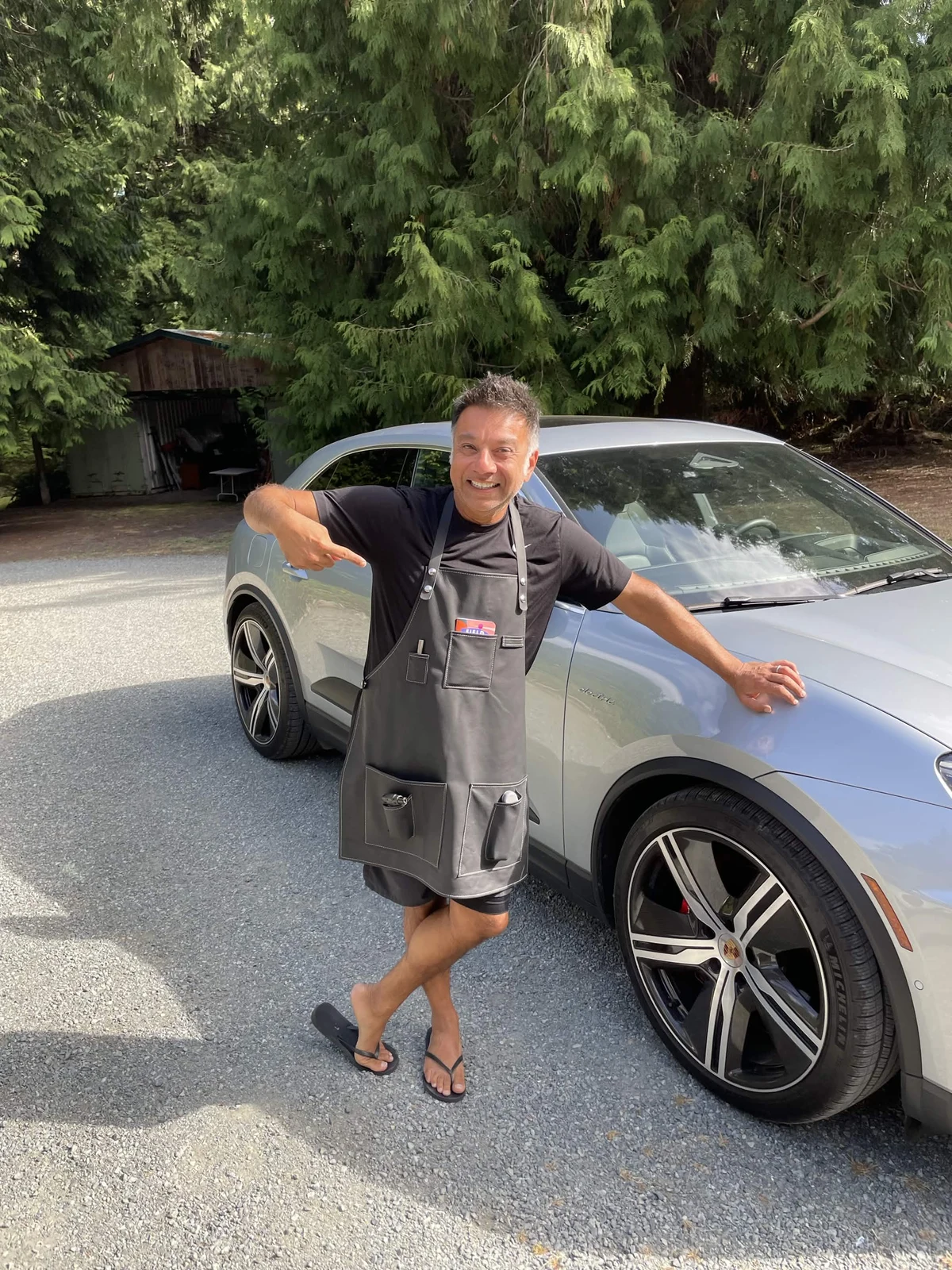 Customer wearing a gray leather apron beside a car outdoors