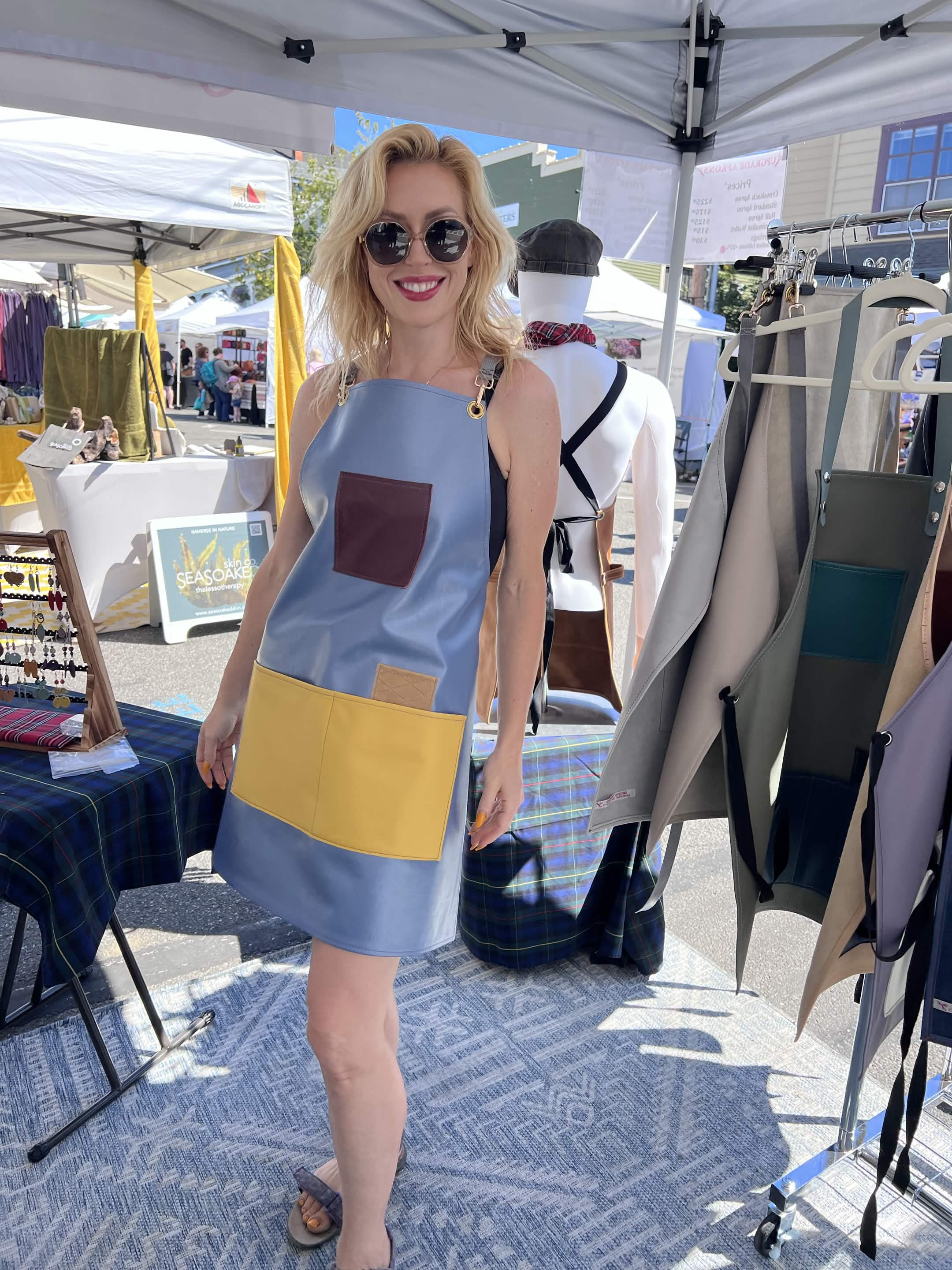 A customer wearing a blue and yellow leather apron at Coupeville Arts Festival.