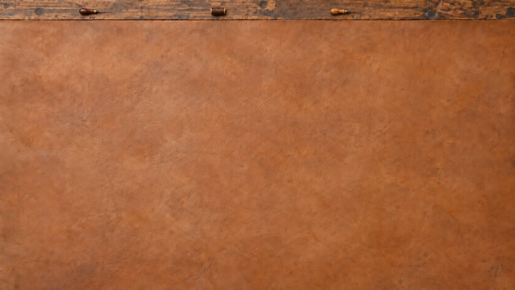 Leather-covered craftsman's workbench with tools set along the far top rim
